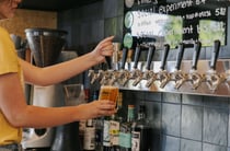 A staff member pulling a pint of craft beer behind the counter at B.Effect in Wanaka.