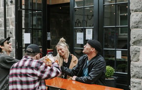 A group of people sat around a table drinking beer at Steamer Basin, Dunedin.
