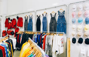 Denim overalls and hats on a wall at Emporium Vintage Boutique Wellington.