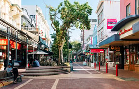 People sitting on tables on Cuba Street in Wellington.