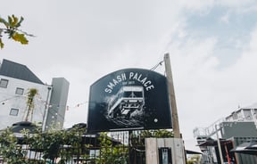 A large black and white sign for Smash Palace on High Street.