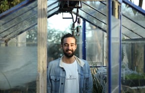 Jayden Kilnac looking to camera outside a glass house.
