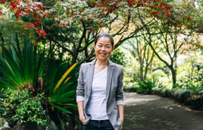 Lisa smiling to camera amongst some beautiful trees.