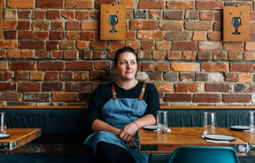 Leslie Hottiaux sitting in her restaurant.