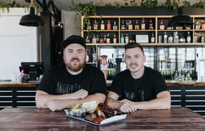 Tristan and Nathan looking to camera inside Smokey T's.
