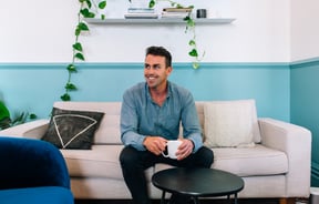 A photo of Matt Stark sitting on a couch.