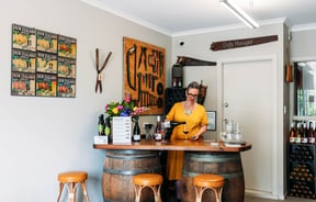 Wine tasting area with manager standing behind it and pouring glasses of wine at Ōhau Wines.