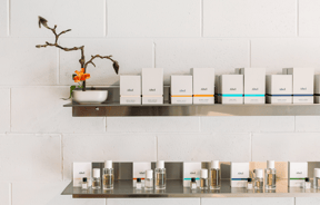 White perfume boxes displayed on a steal shelf.