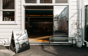 The exterior of the elegant Abel building with a white weatherboard outside.