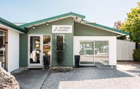 Green weatherboard building exterior of Aspiring Guides.