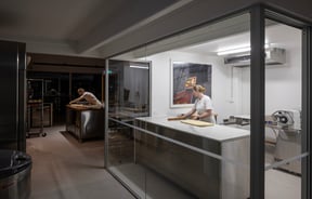 Two bakers working in the empty bakery in the dark morning.