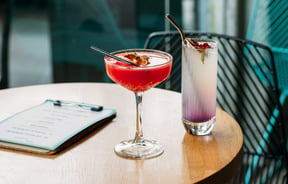 Two of the Banh Mi cocktails, one in a tall tumbler and one in a coupe glass.