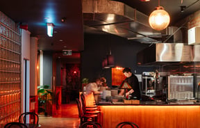 A staff member working behind the bar at Bar Magda.
