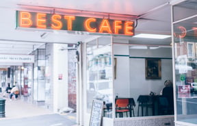 Orange neon sign on the exterior of the cafe.
