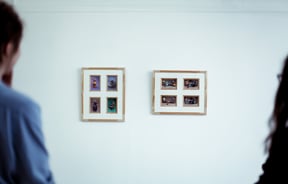 Looking at artwork on a white wall.