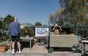 A little pizza cart on a sunny day.