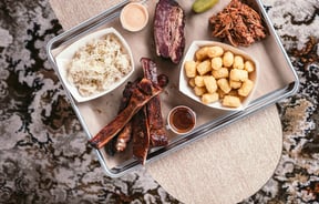 Food on a table above a vintage carpet.