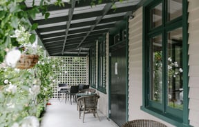 A covered verandah outside Cafe Verde, surrounded by greenery in Geraldine.