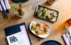 Plates of food next to a menu that sees 'Culprit' in black and white.