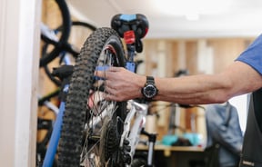 Side view of a man holding a bike tyreat Cycle Ventures in Waitaki.