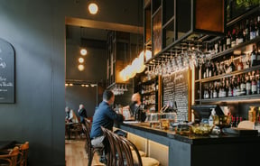 Image of the bar with bar stools with big feature lighting above the bar.