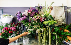 A hand reaching for flowers.