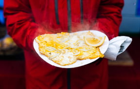 A giant whitebait pattie with a lemon wedge on the side.