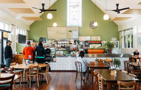 A large cafe space with a green painted wall.