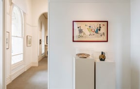 Upstairs exhibition space at Forrester Gallery highlighting Japanese artwork and ceramics in glass cases