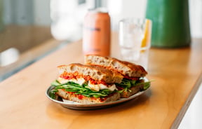 Sandwich on a wooden bench top at Fred's, Wellington.