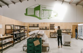 The interior of Freshlink Grocer where there is a costumer walking around shopping.