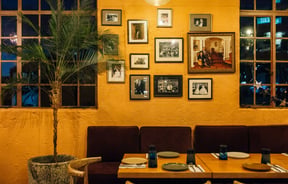 Close up of seating area and old photographs and artwork on the wall at Gemmayze Street.