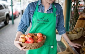 A woman with apples in a basket at Harbour Co-op in Lyttelton.