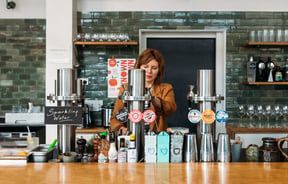 Woman pouring a tap beer behind the bar at Hayes Common in Hamilton.
