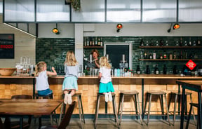Three little girls at the counter at Hayes Common, Hamilton.