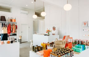 A woman working behind a white counter in a beautifully decorate store.