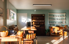 Shop interior of Hill Road Orchard & Farm Shop with tables and shelves of products set up.