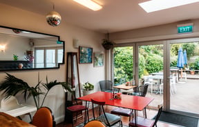 Tables and chairs inside a brightly cafe.