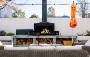 An outdoor fire and white seating at Hotel Montreal in Christchurch on a sunny day.