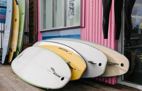 Stack of surfboards leaning against a wall at Kaikōura Surf Company.