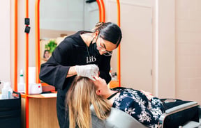 Beautician doing a woman's eyebrow treatment.