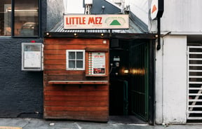 A little wooden hut entrance to Little Mez Queenstown.