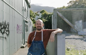 Giulio Sturla standing outside his restaurant smiling to camera.