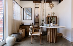Natural coloured furniture set up in a nice display in the corner of a store.