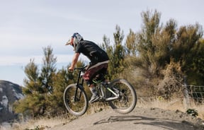 Man doing little jump on his mountain bike.