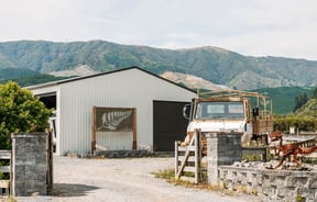 Truck outside MnM Collection Garage with views of hills in background