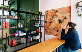 A woman drinking coffee at a cafe table.