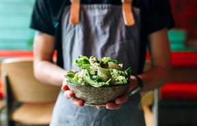 Person Holding a salad.
