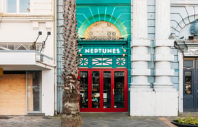 The red and green exterior of Neptunes Pizzeria Gisborne.