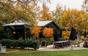 The exterior of Orchard Garden Cafe amongst autumnal foliage.